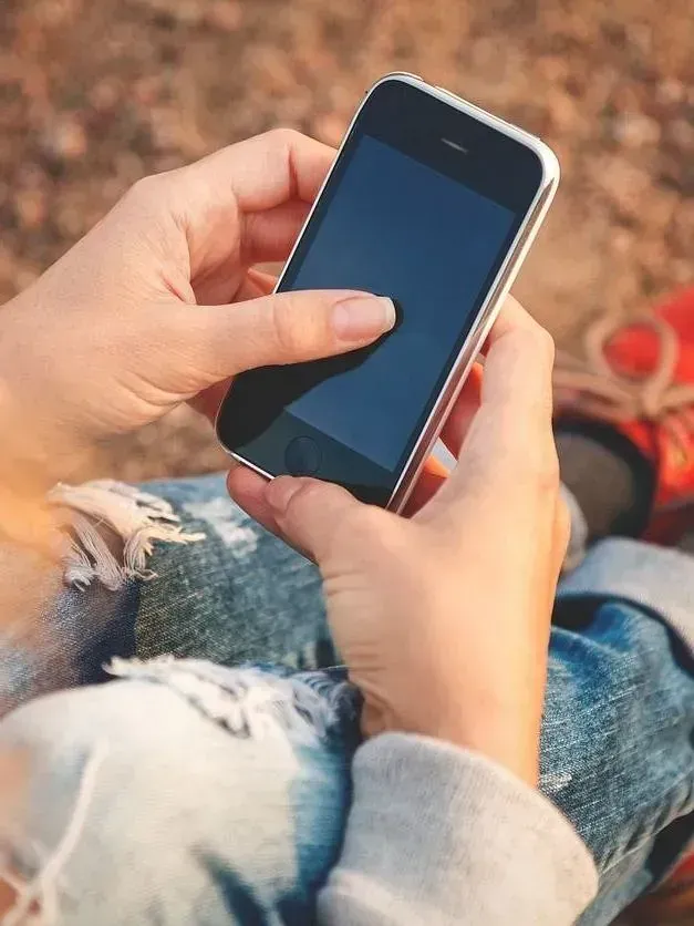 Una persona sostiene un teléfono celular en sus manos.