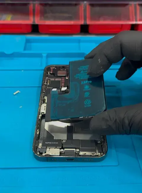 Una persona está sacando la batería de un teléfono celular.