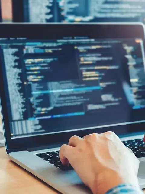 Una persona está escribiendo en una computadora portátil.