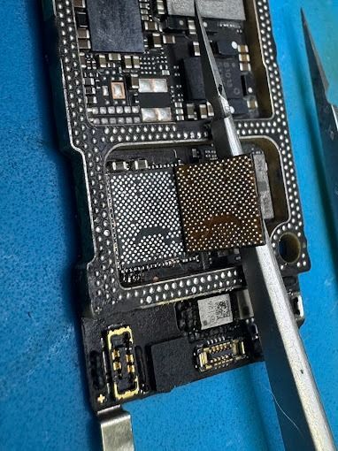 Un primer plano de una placa base de un teléfono celular con un par de tijeras.