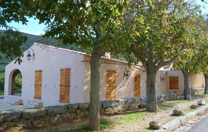 Maison de plain-pied avec des volets en bois