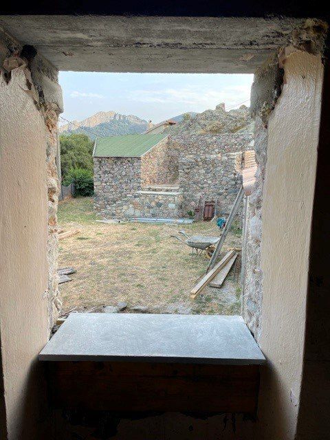 Trou dans un mur avec vue sur le jardin d'une maison