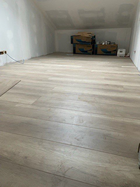 Parquet marron avec des cartons au fond de la pièce