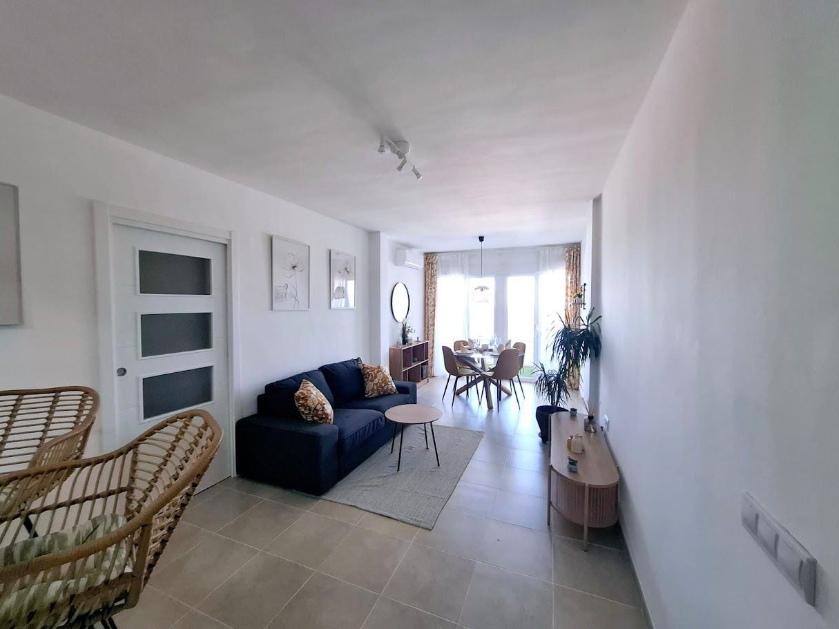 Comedor con mesa redonda para dos con vista al mar a través de una puerta corrediza.