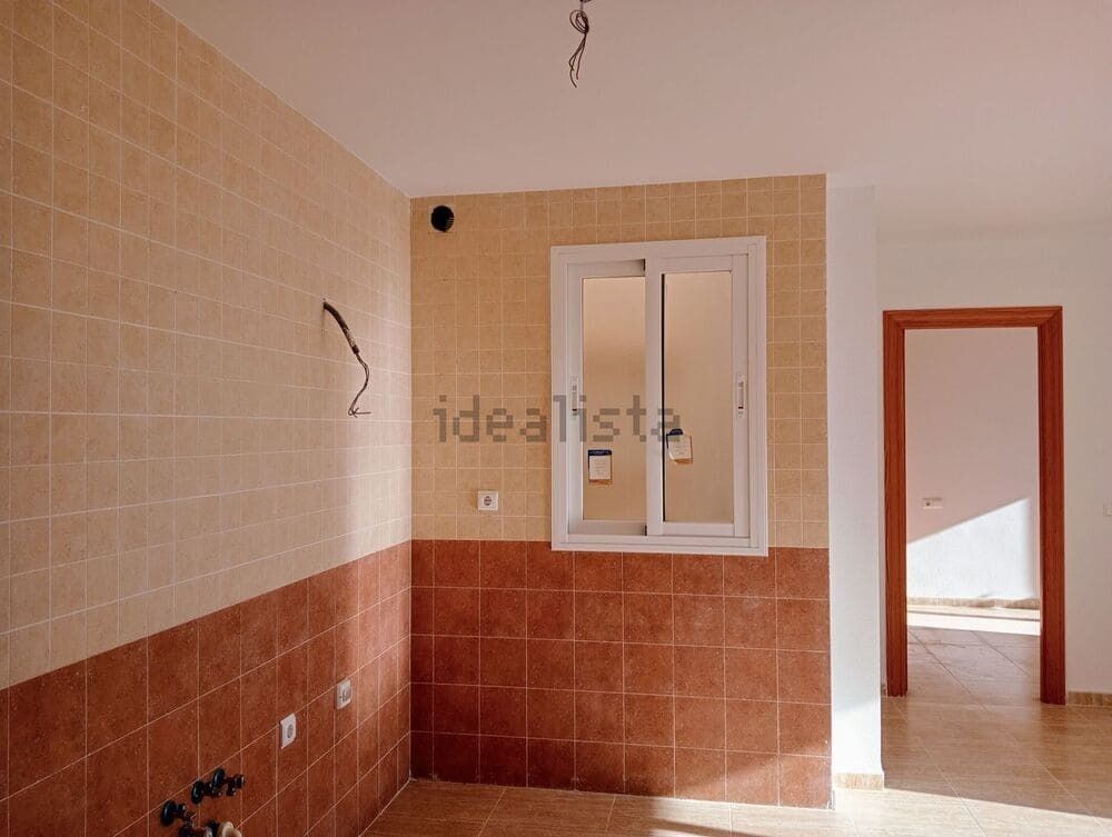 Una cocina vacía con una ventana y una puerta.