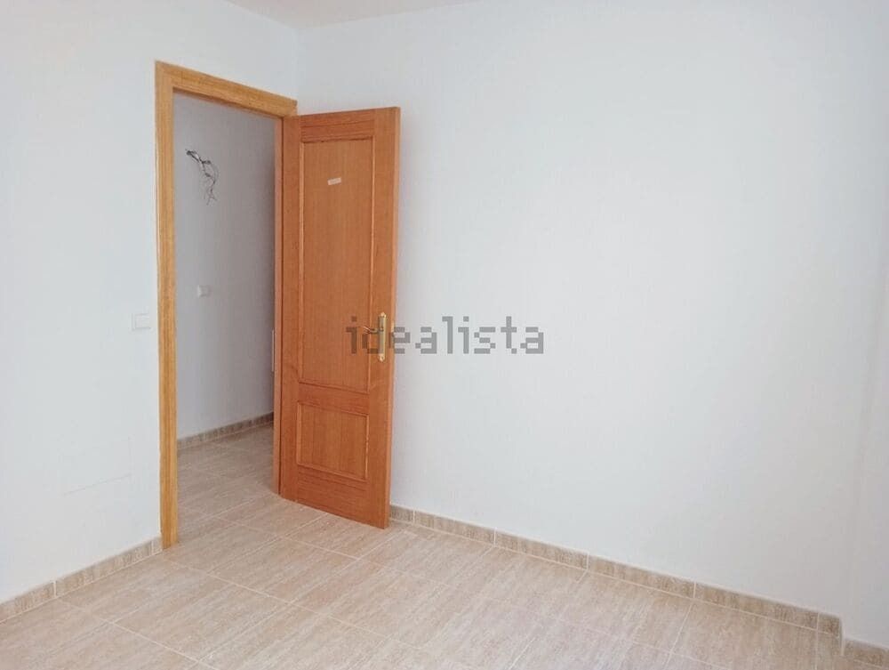 Una habitación vacía con una puerta abierta y la palabra idealista en la pared.
