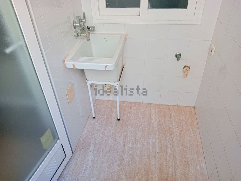 Un lavadero con fregadero y ventana.
