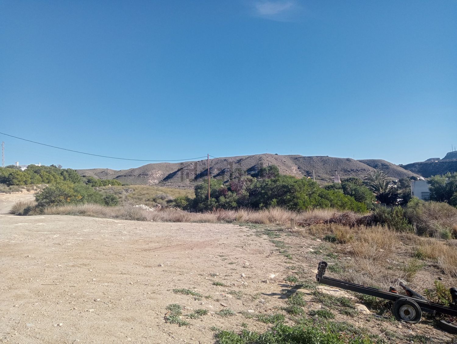 Un campo de tierra con una montaña al fondo