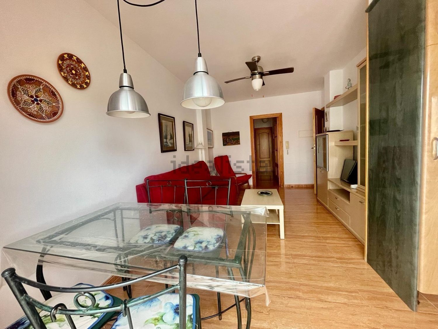 Una sala de estar con una mesa de cristal y sillas.