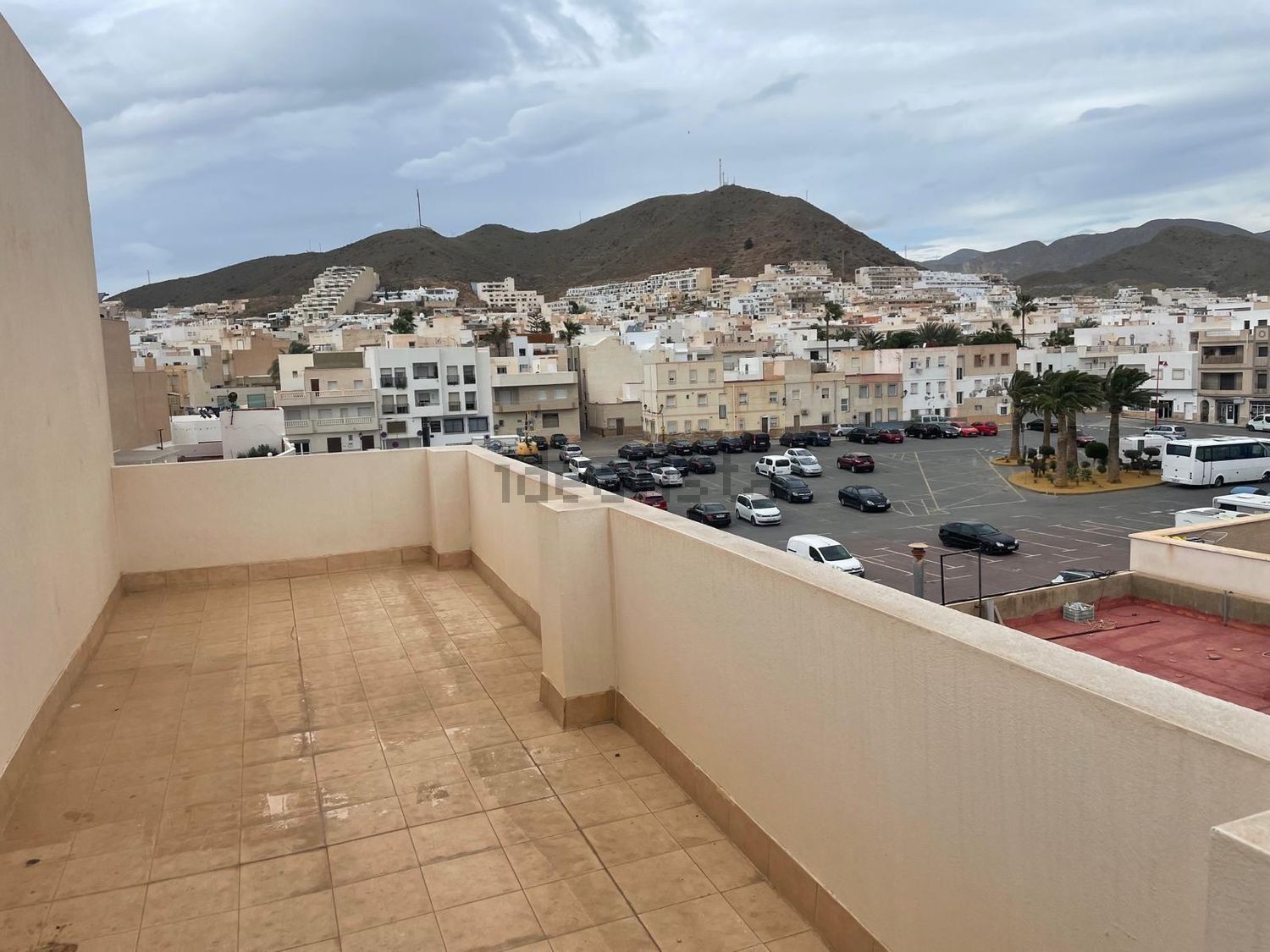 Un balcón con vista a la ciudad y las montañas.
