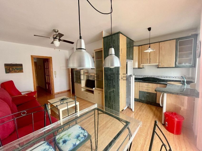Una sala de estar con mesa y sillas y una cocina.