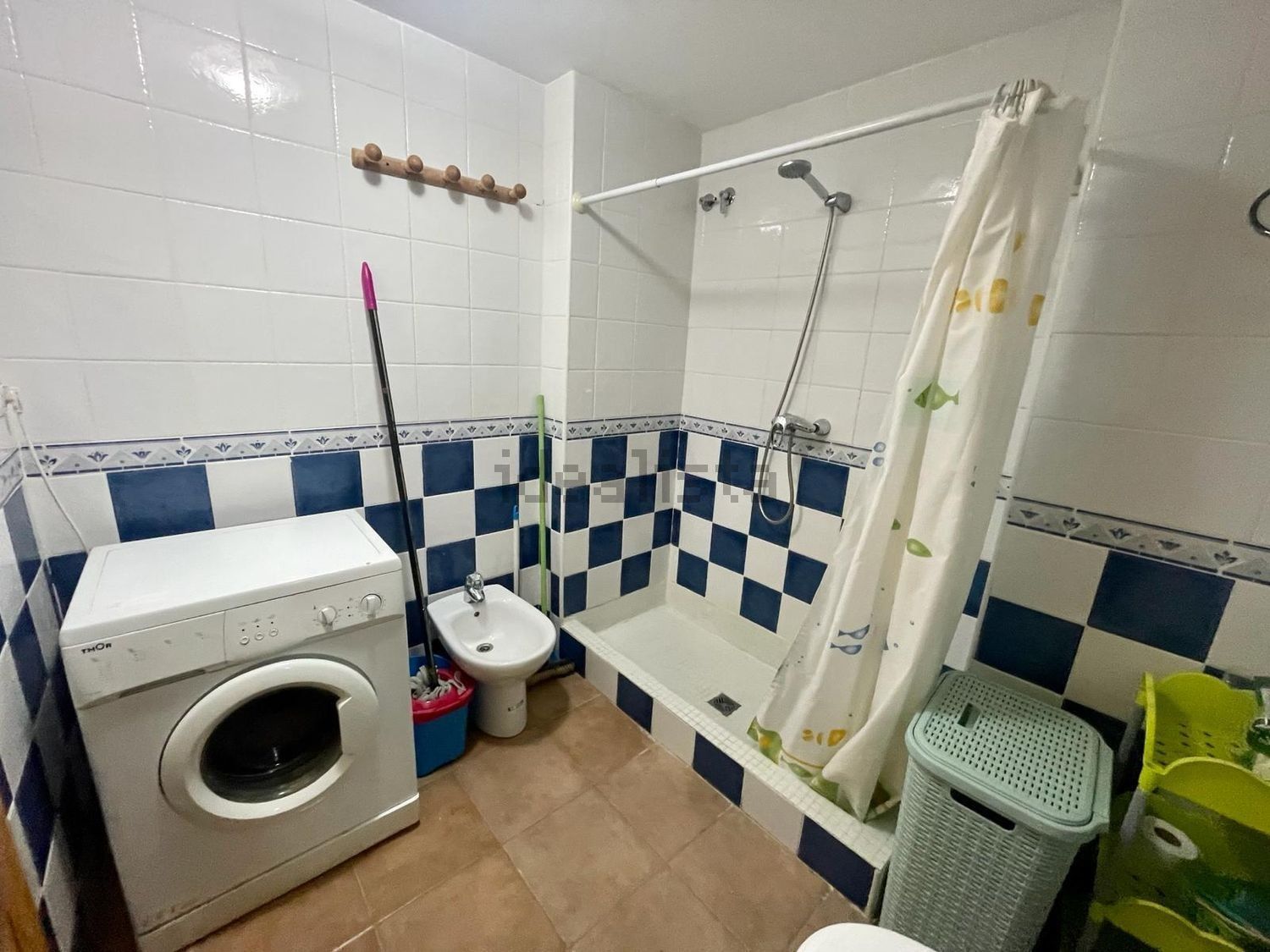 Un baño con lavadora, bidet y ducha.