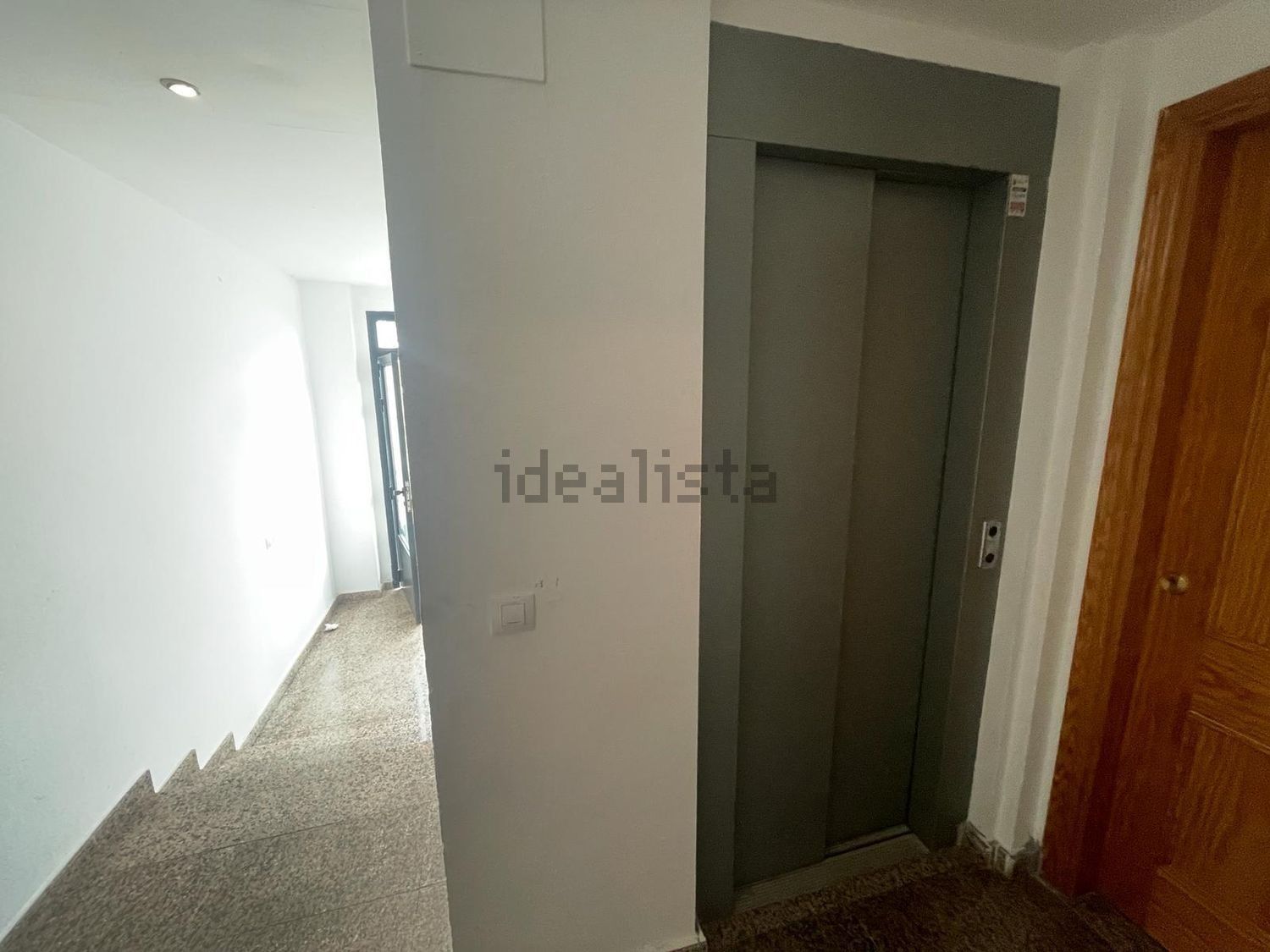 Un ascensor está situado en medio de un pasillo.