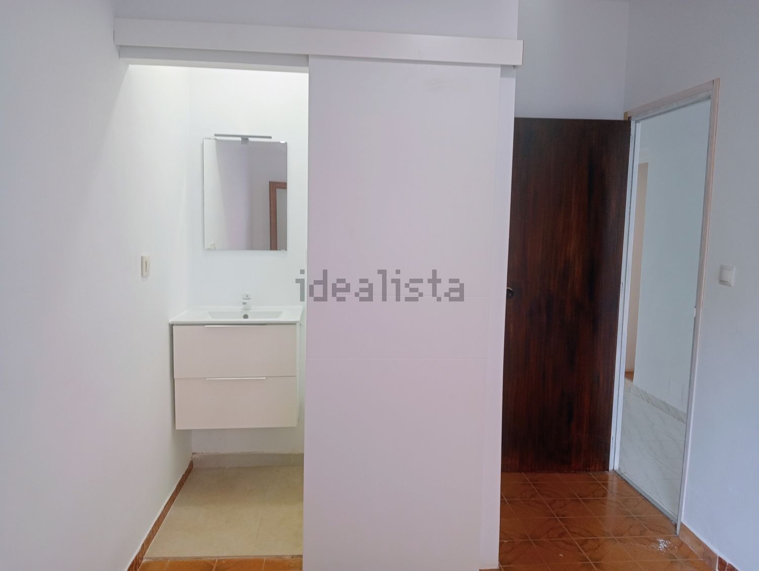 Un baño con puerta corrediza de cristal y lavabo.