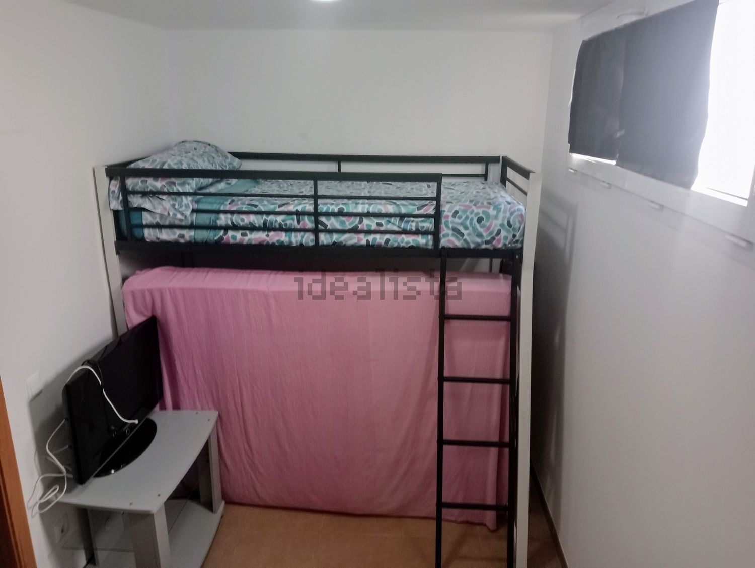 Una litera con escalera en una habitación pequeña.