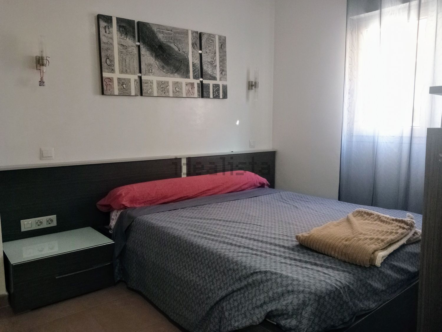 Un dormitorio con una cama grande y un cuadro en la pared.