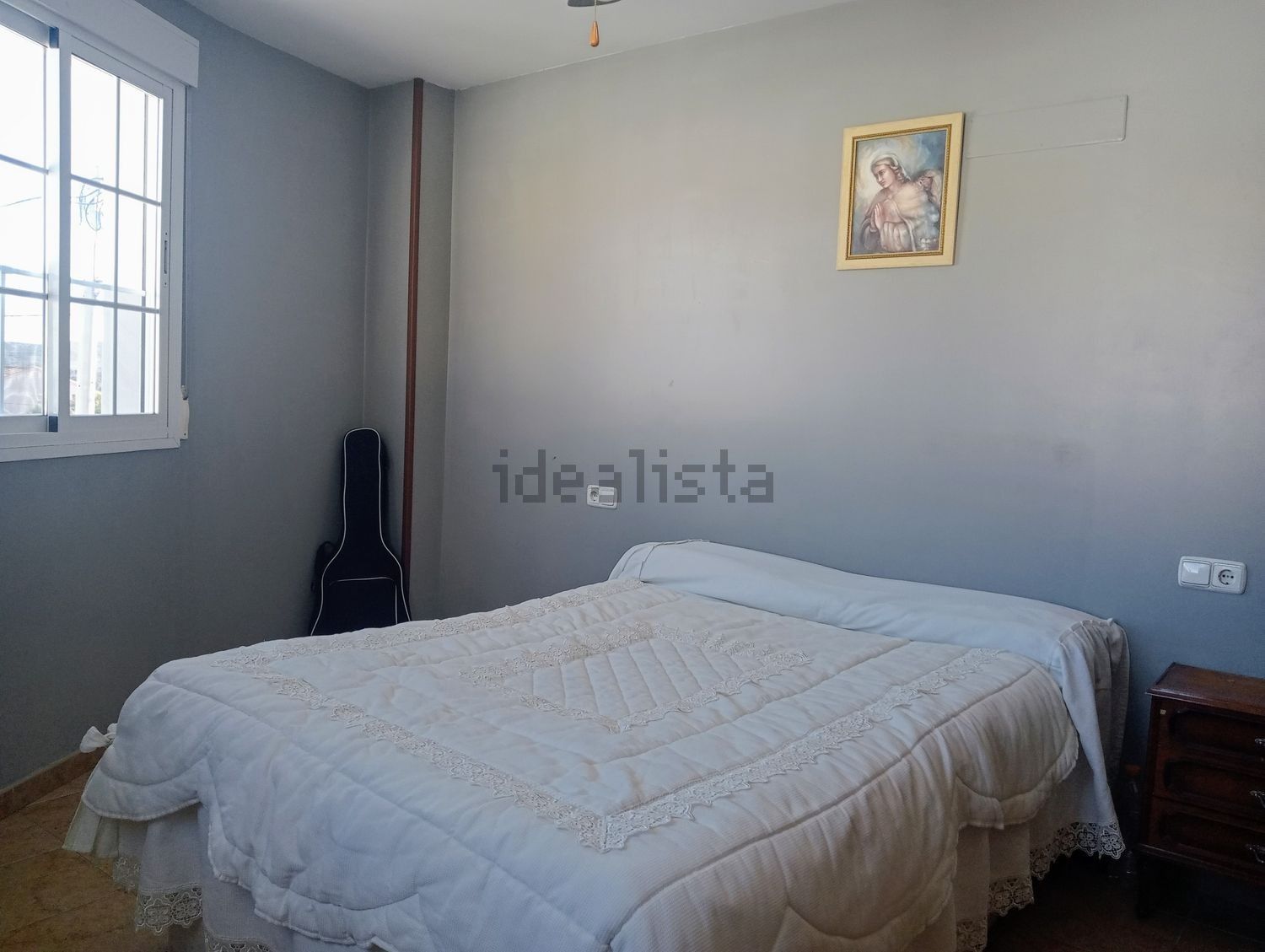 Un dormitorio con una cama grande y un cuadro en la pared.