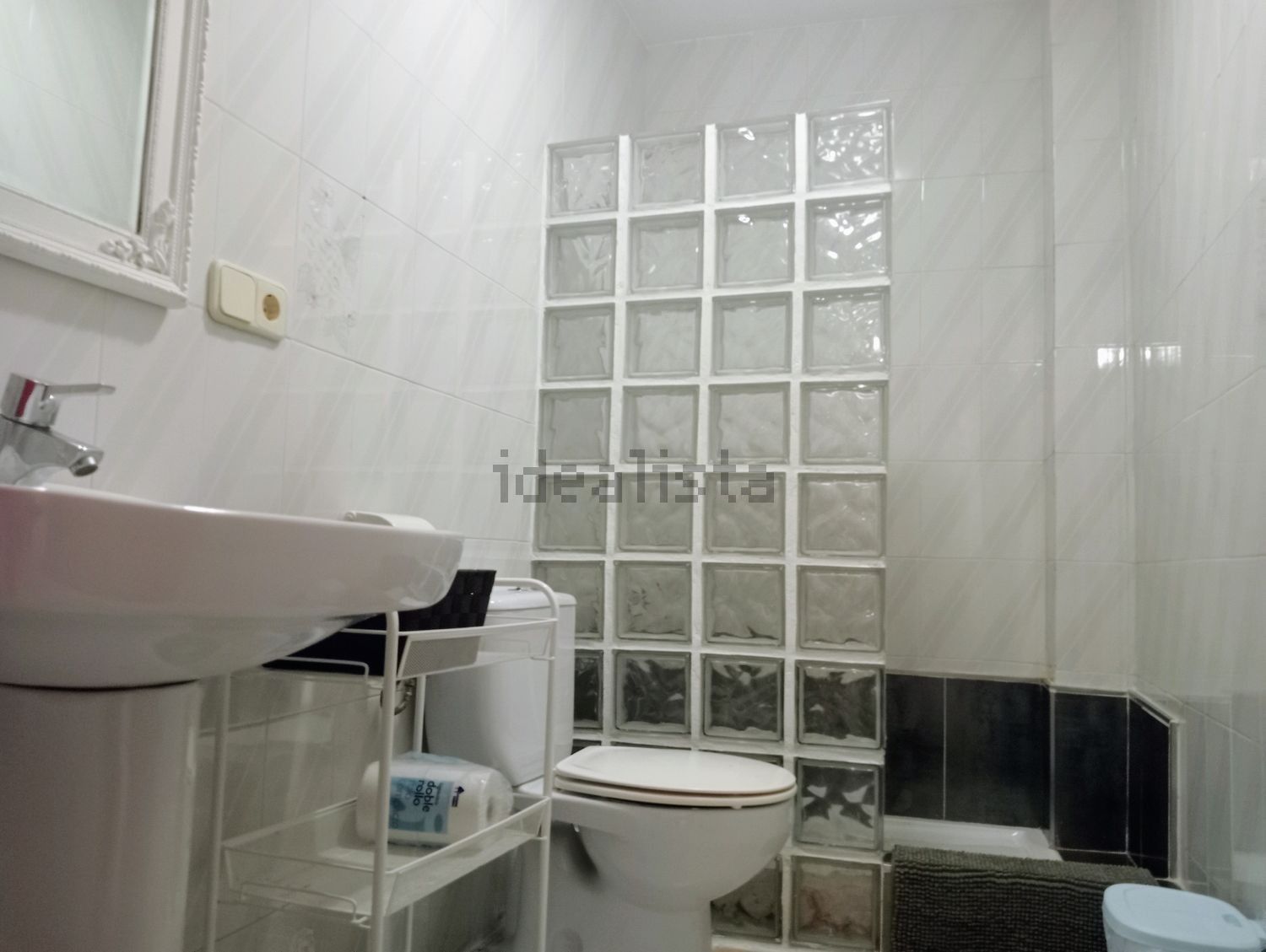 Un baño con inodoro, lavabo, espejo y ducha.