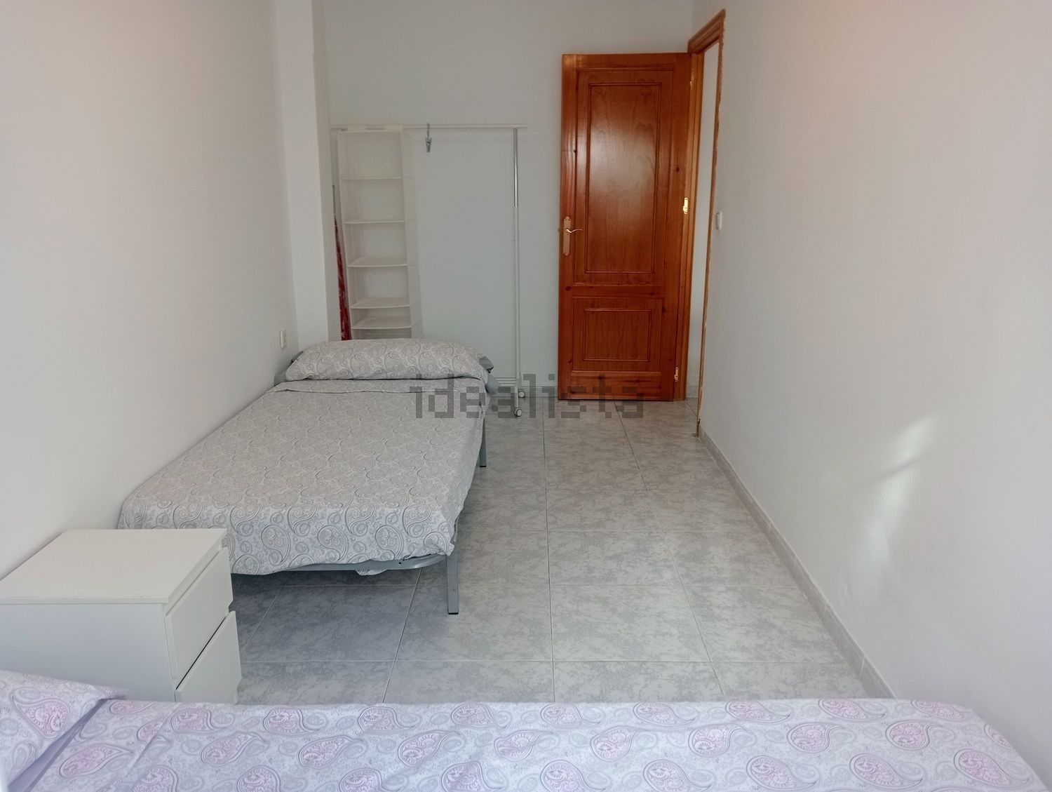 Un dormitorio con dos camas y una puerta que dice idealista