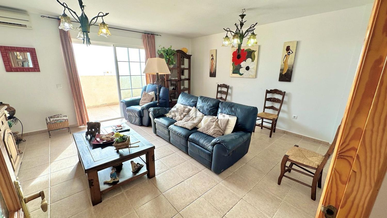 Una sala de estar con un sofá, sillas y una mesa de café.