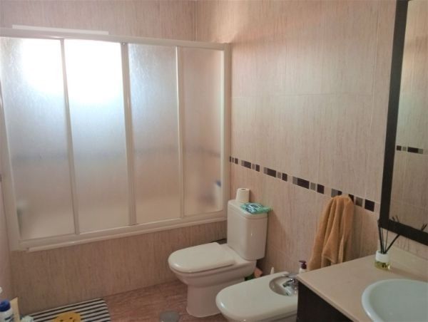 Un baño con inodoro, bidé y cabina de ducha.