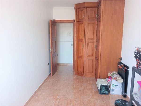 Una habitación con muchos armarios de madera y cajas en el suelo.