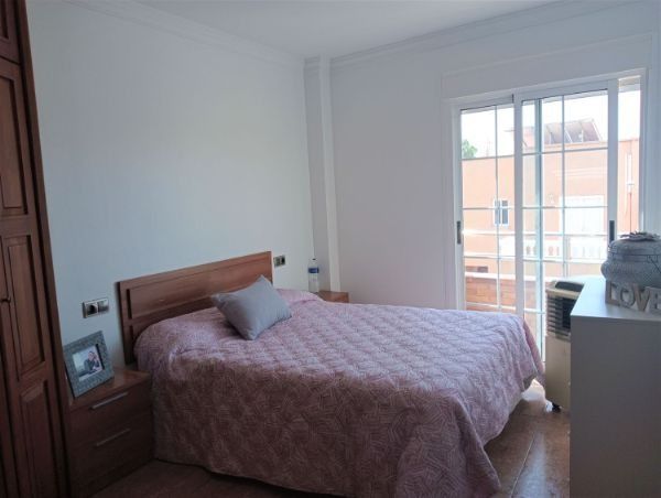 Un dormitorio con una cama y una puerta corrediza de vidrio.