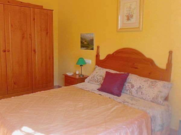 Un dormitorio con una cama, una mesita de noche y una lámpara.