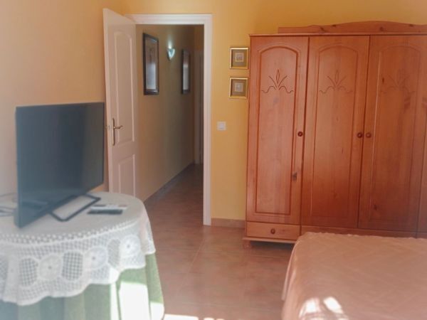 Un dormitorio con una cómoda y un televisor de pantalla plana.
