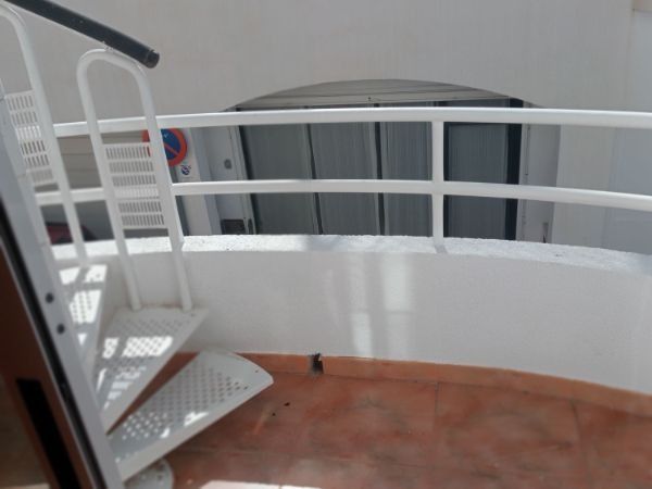 Una escalera de caracol con barandilla blanca en un edificio.