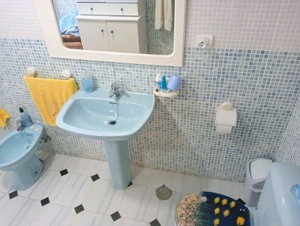 Un baño con lavabo, inodoro y espejo.