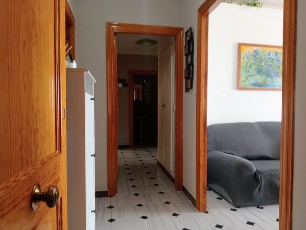Un pasillo con un sofá y un cuadro en la pared.