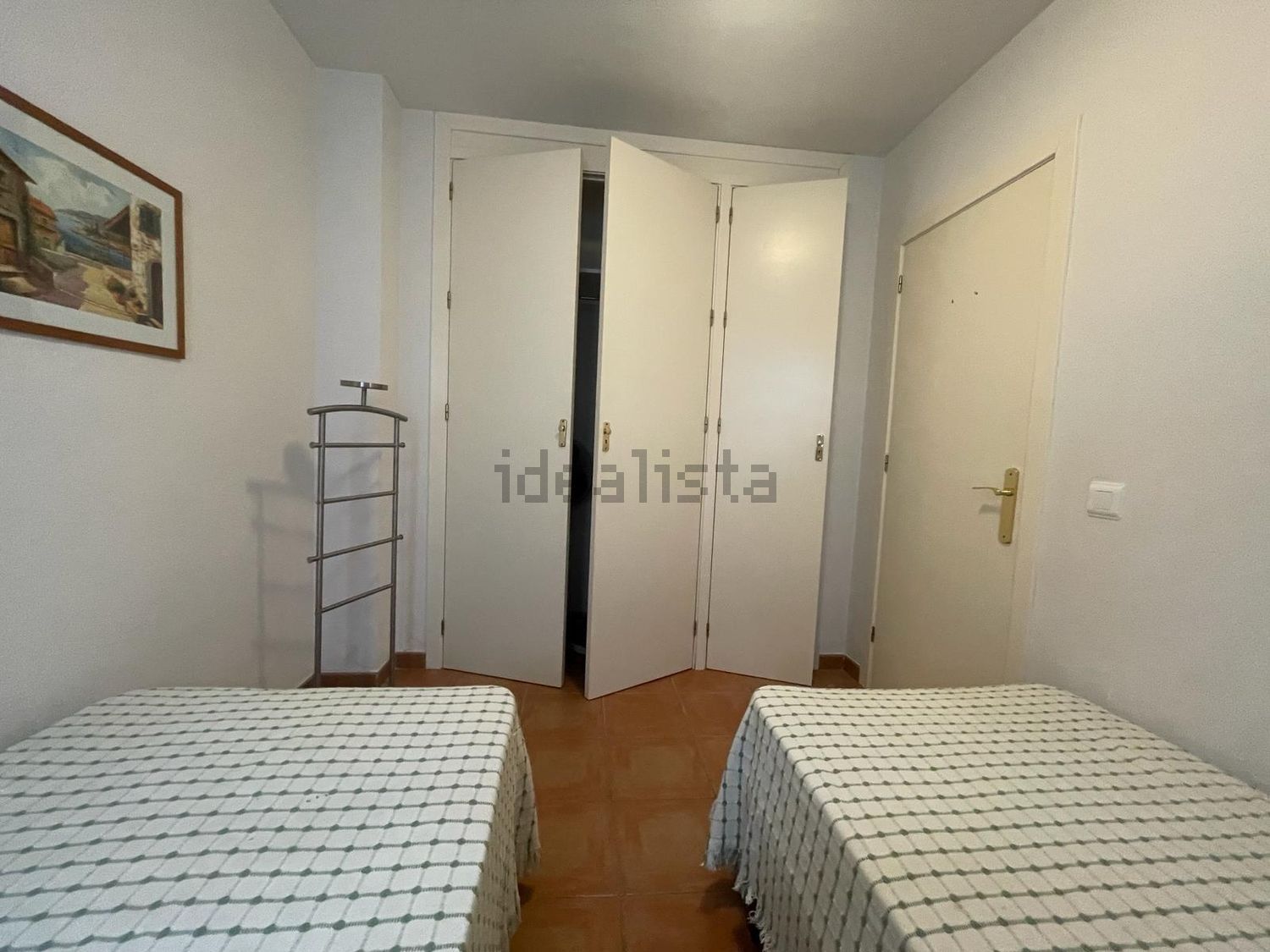 Un dormitorio con dos camas y un armario que dice idealista