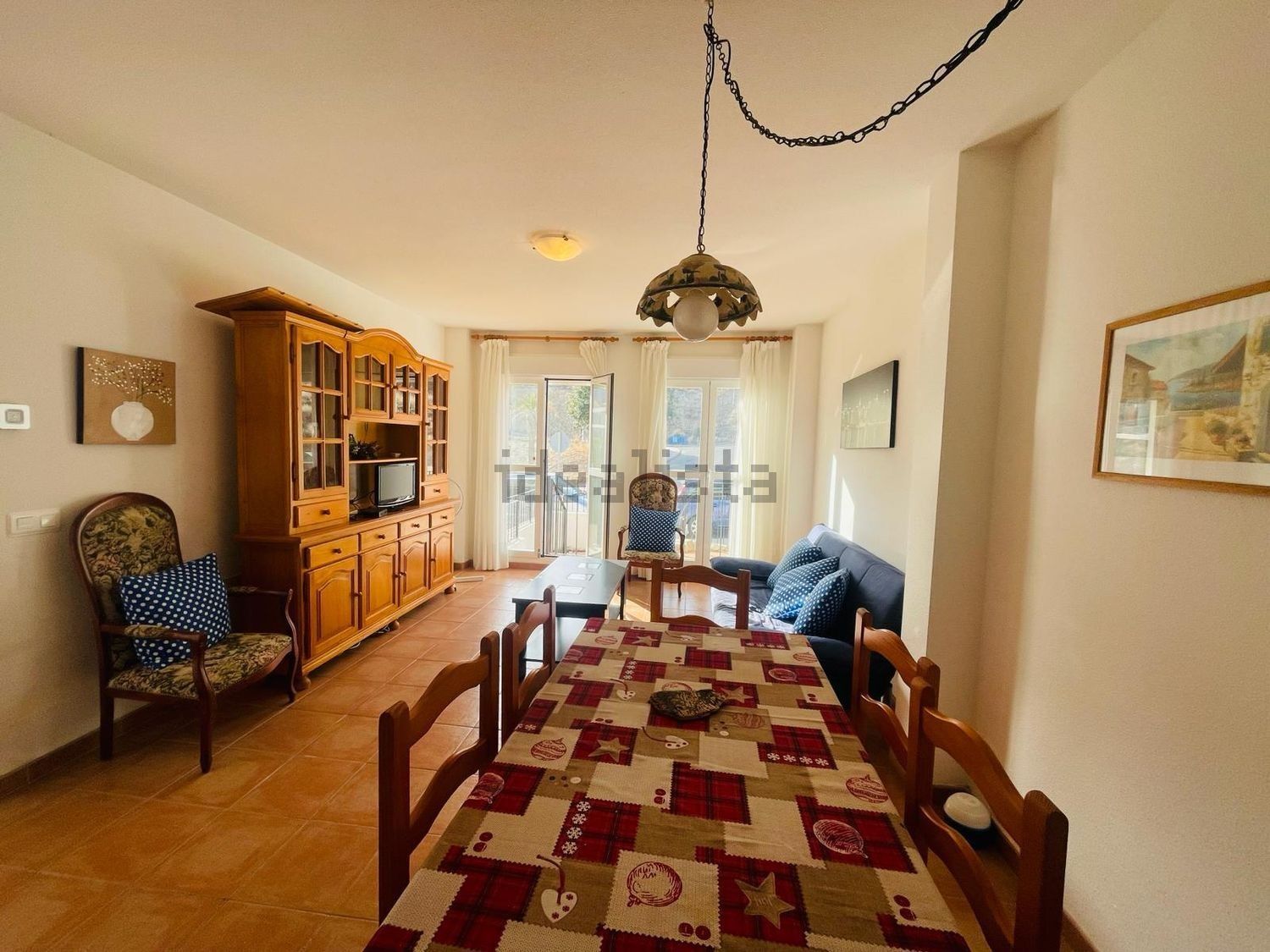 Una sala de estar con una mesa larga y sillas.