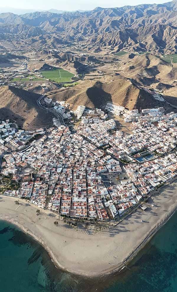 Una vista aérea de una ciudad rodeada de agua y montañas.
