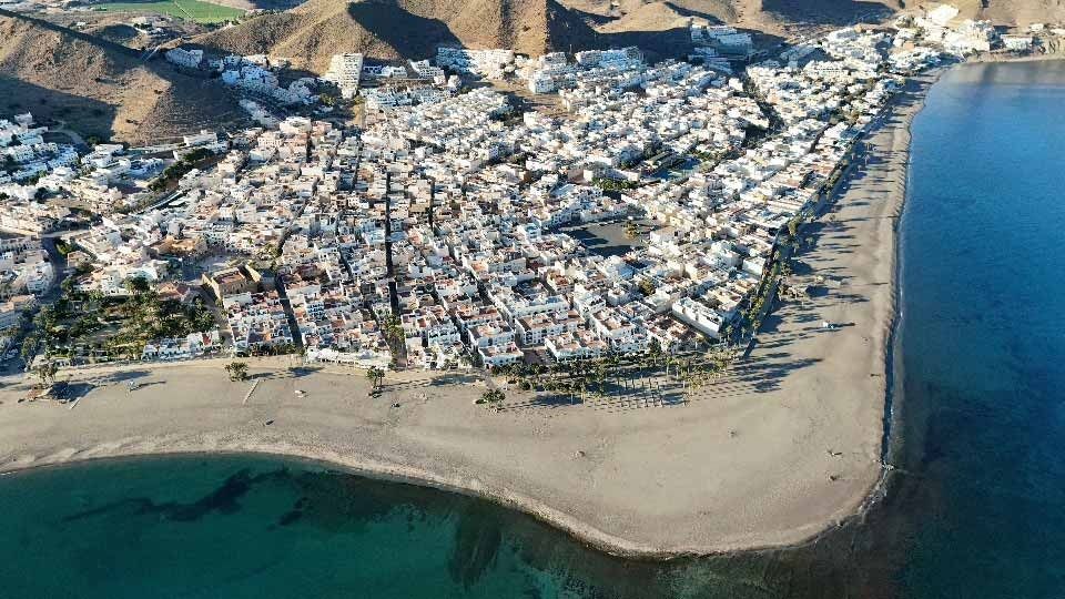 Una vista aérea de una ciudad rodeada de agua y montañas.