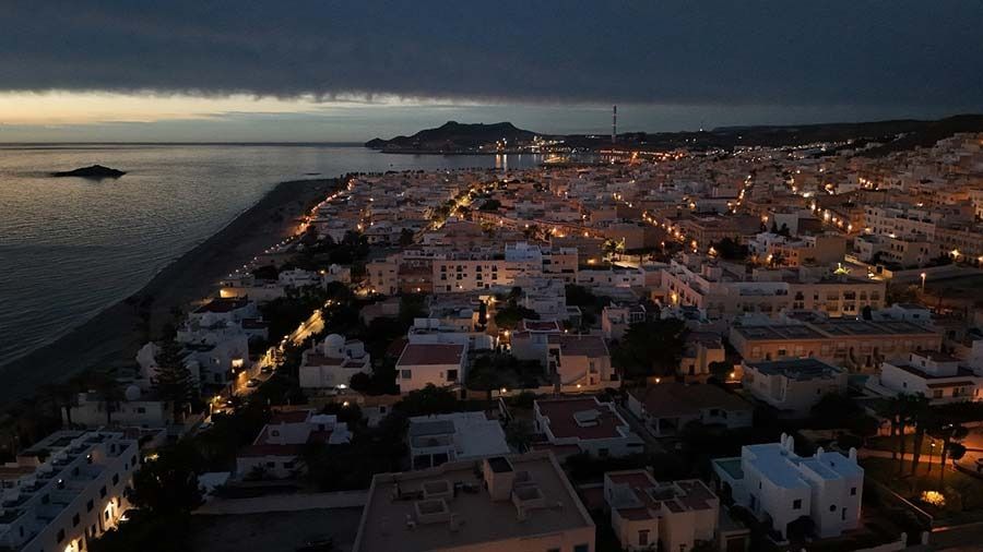 Una vista aérea de una ciudad junto al océano por la noche.
