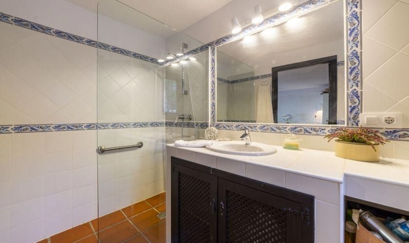 Un baño con lavabo, espejo y ducha.