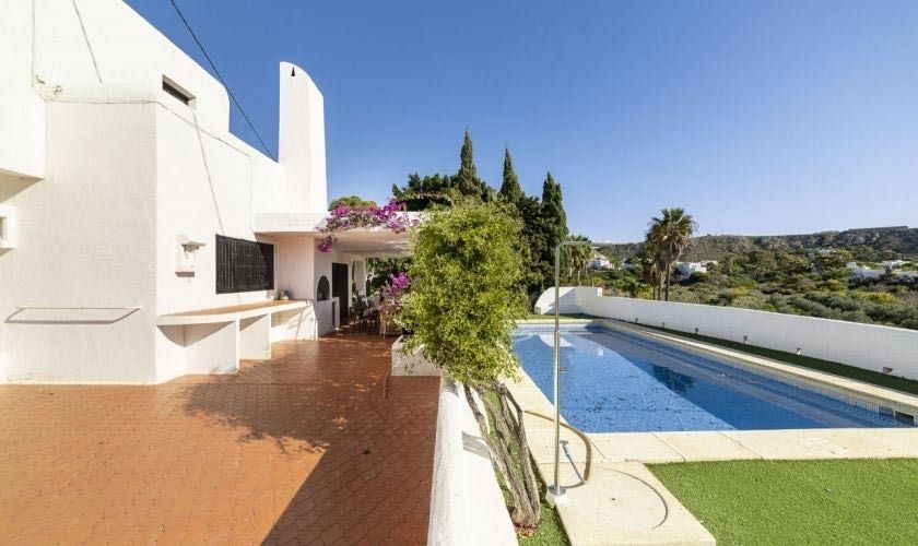 Una gran casa blanca con una gran piscina delante de ella.