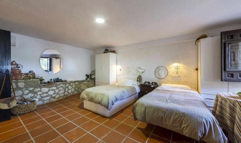 Un dormitorio con dos camas y suelo de baldosas.