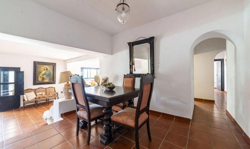 Un comedor con una mesa y sillas y un espejo.
