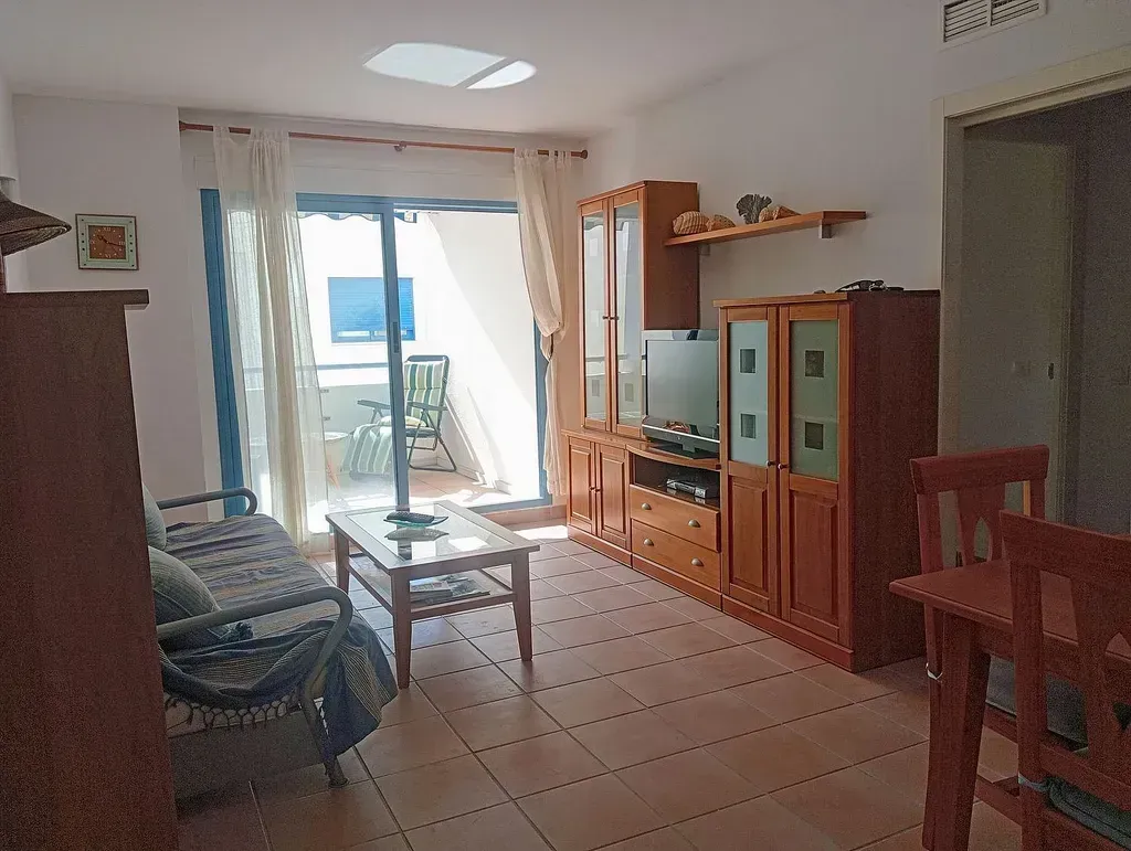 Una sala de estar con un sofá, una mesa y un televisor.