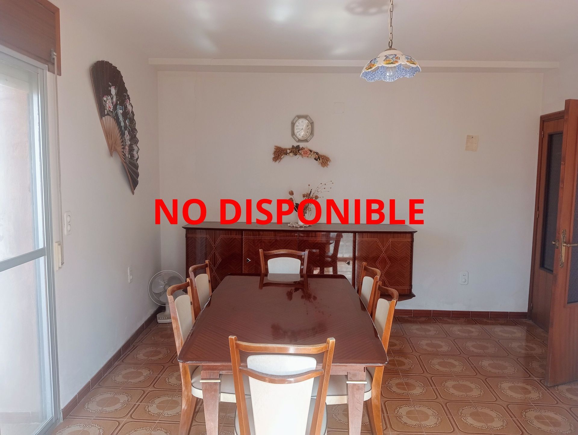 Un comedor con una mesa y sillas y un cartel que dice no disponible