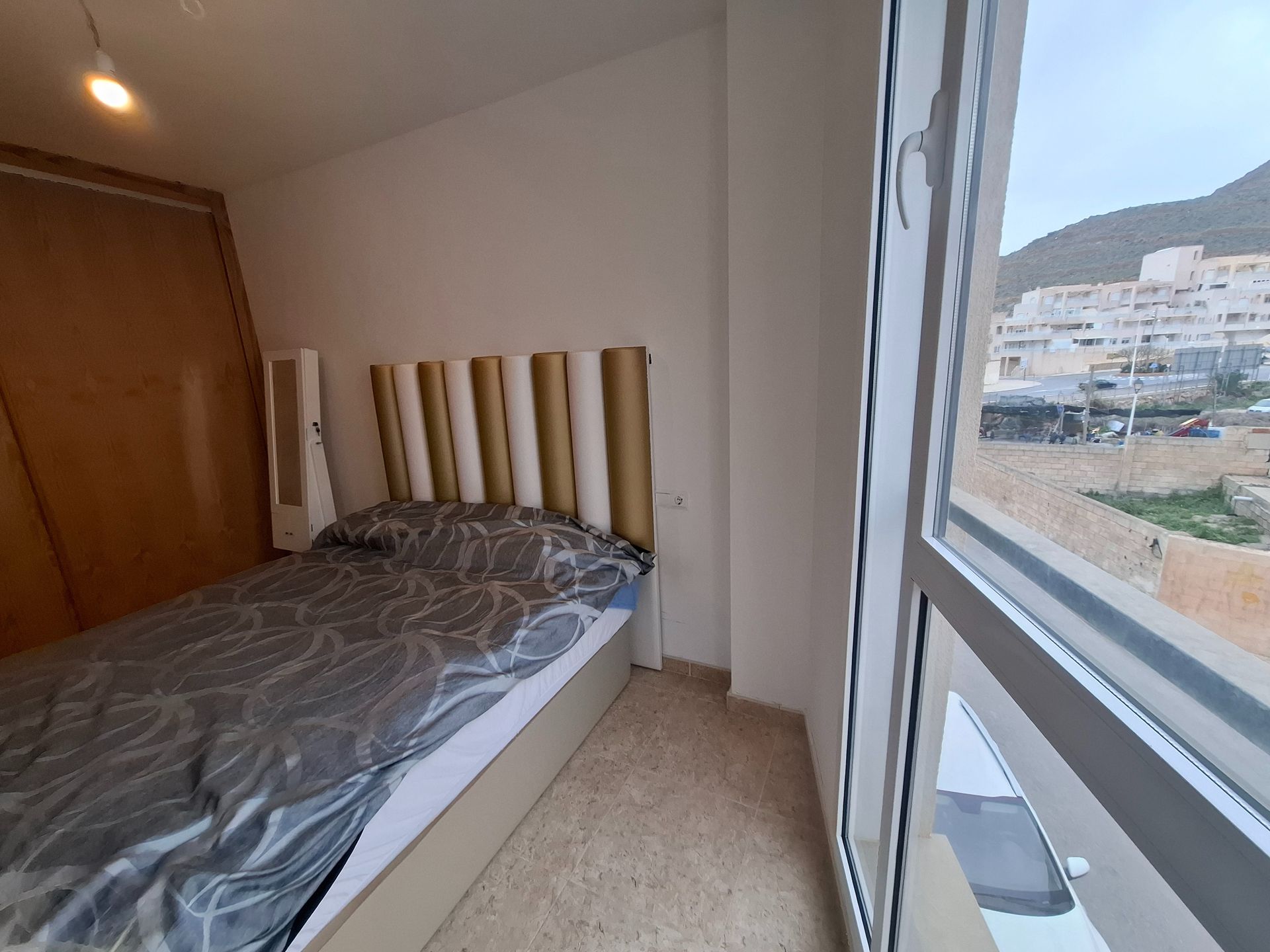 Un dormitorio con una cama y una ventana grande.
