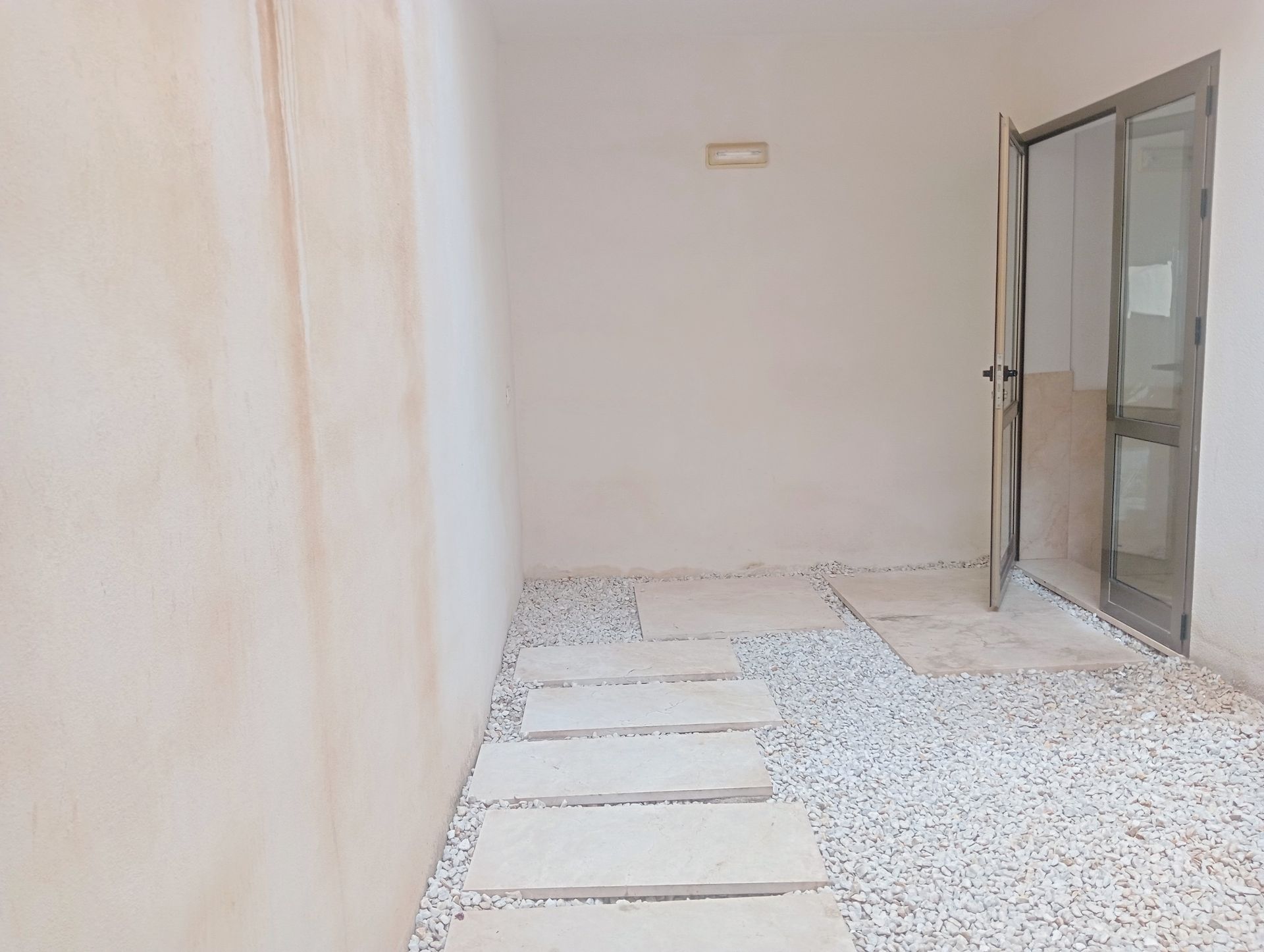 Una habitación vacía con una puerta y escalones que conducen a ella.