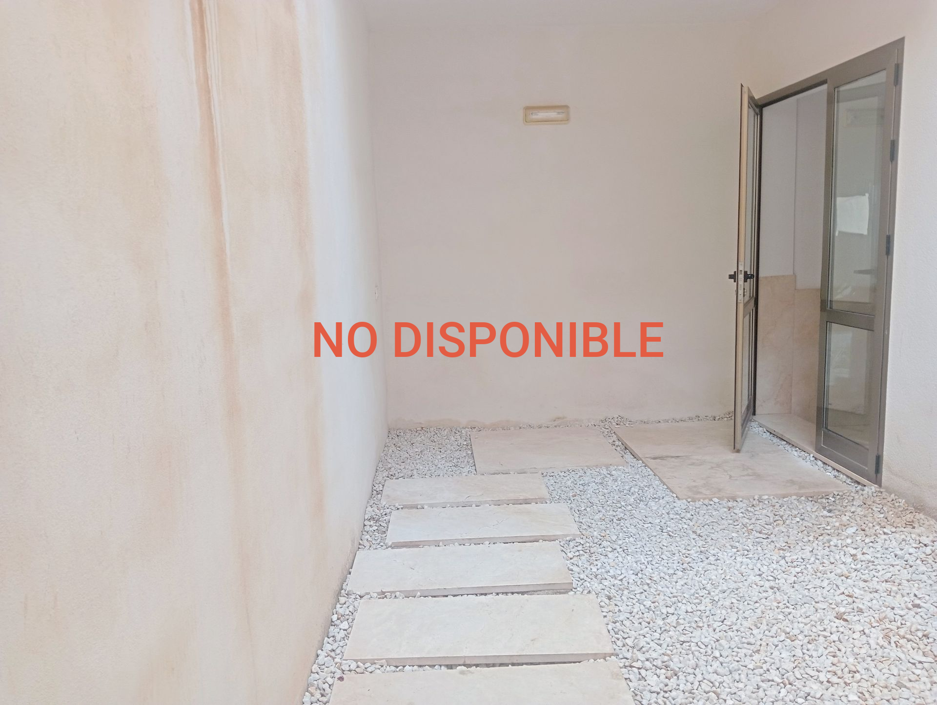 Una habitación vacía con una puerta y escalones que conducen a ella.