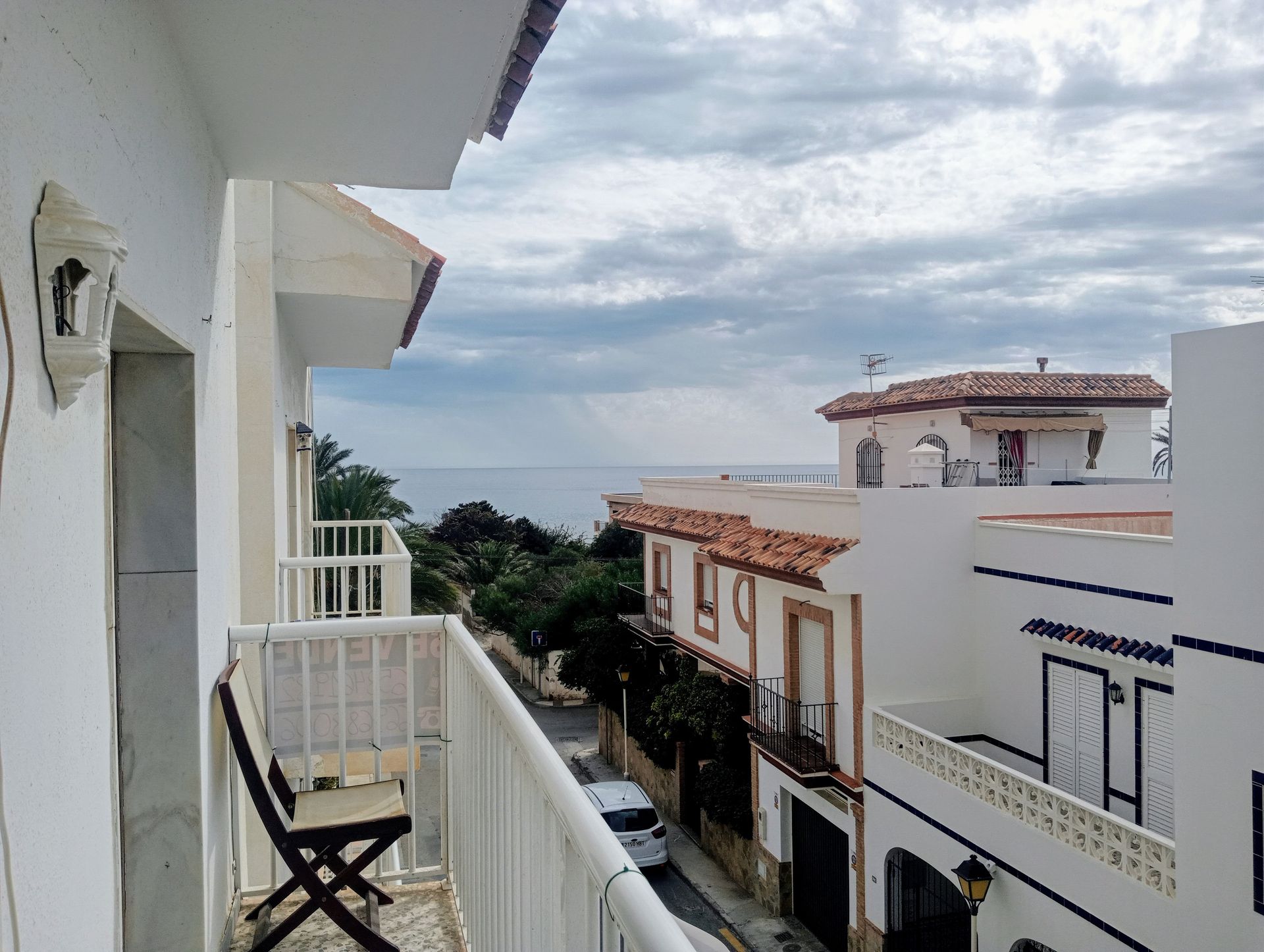 Un balcón con mesa y sillas con vista al mar.