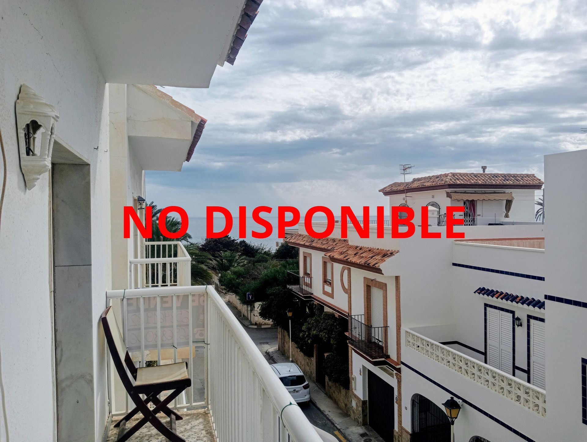 Un balcón con mesa y sillas con vista al mar.