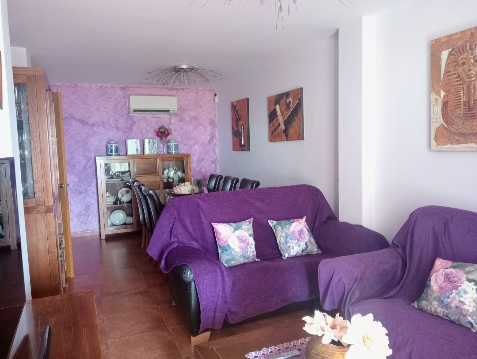 Una sala de estar con muebles morados y un sofá morado.