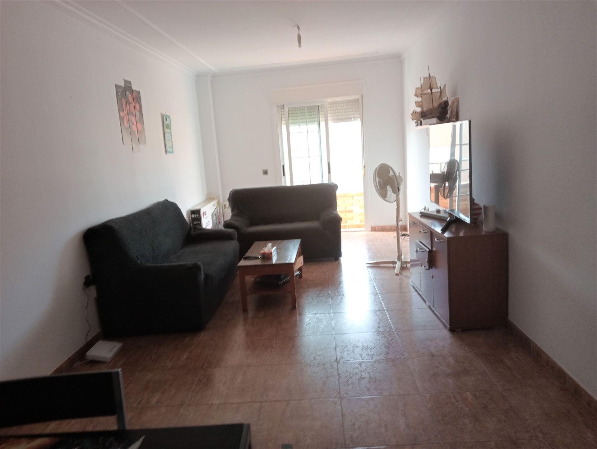 Una sala de estar con un sofá y un televisor